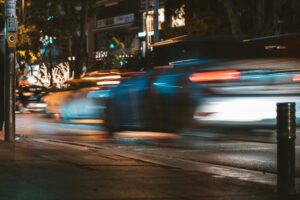 Vehicles driving quickly at night.